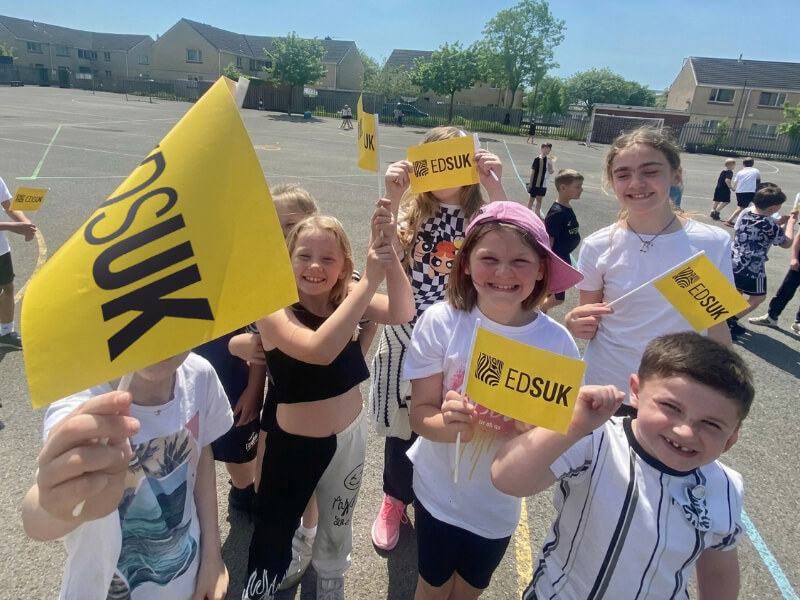 Group of children smiling and holding EDS UK flags