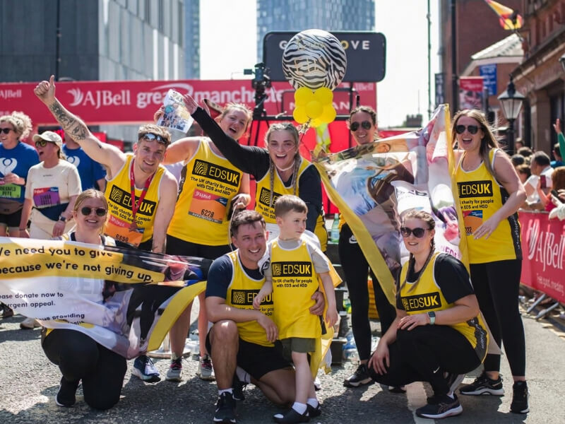 Group of fundraisers wearing EDS UK t-shirts and cheering